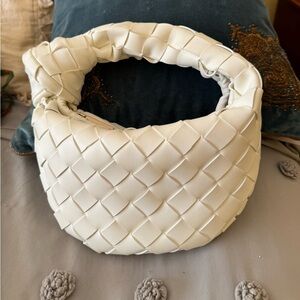 Woven white faux leather bag with knot handle.